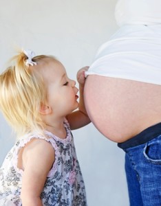 Little Girl Kissing Moms Belly